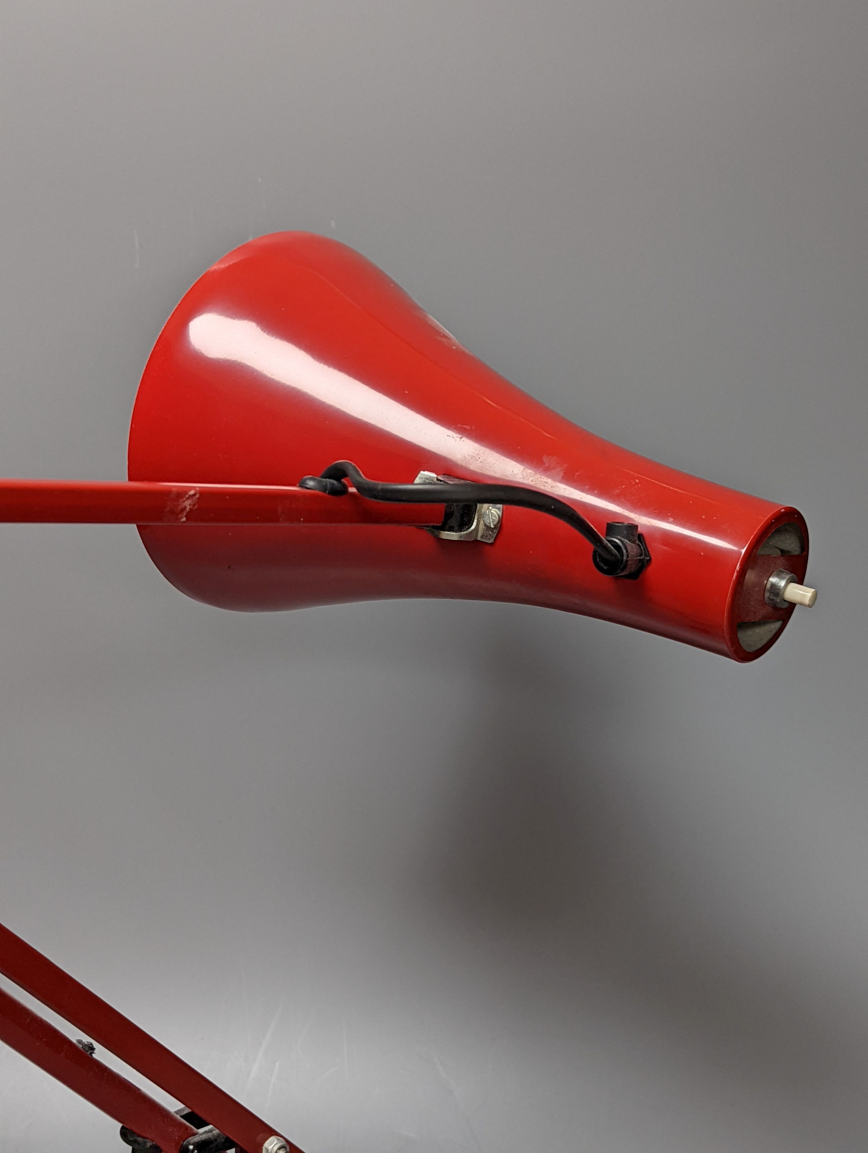 A red anglepoise table lamp, 79 cms high.
